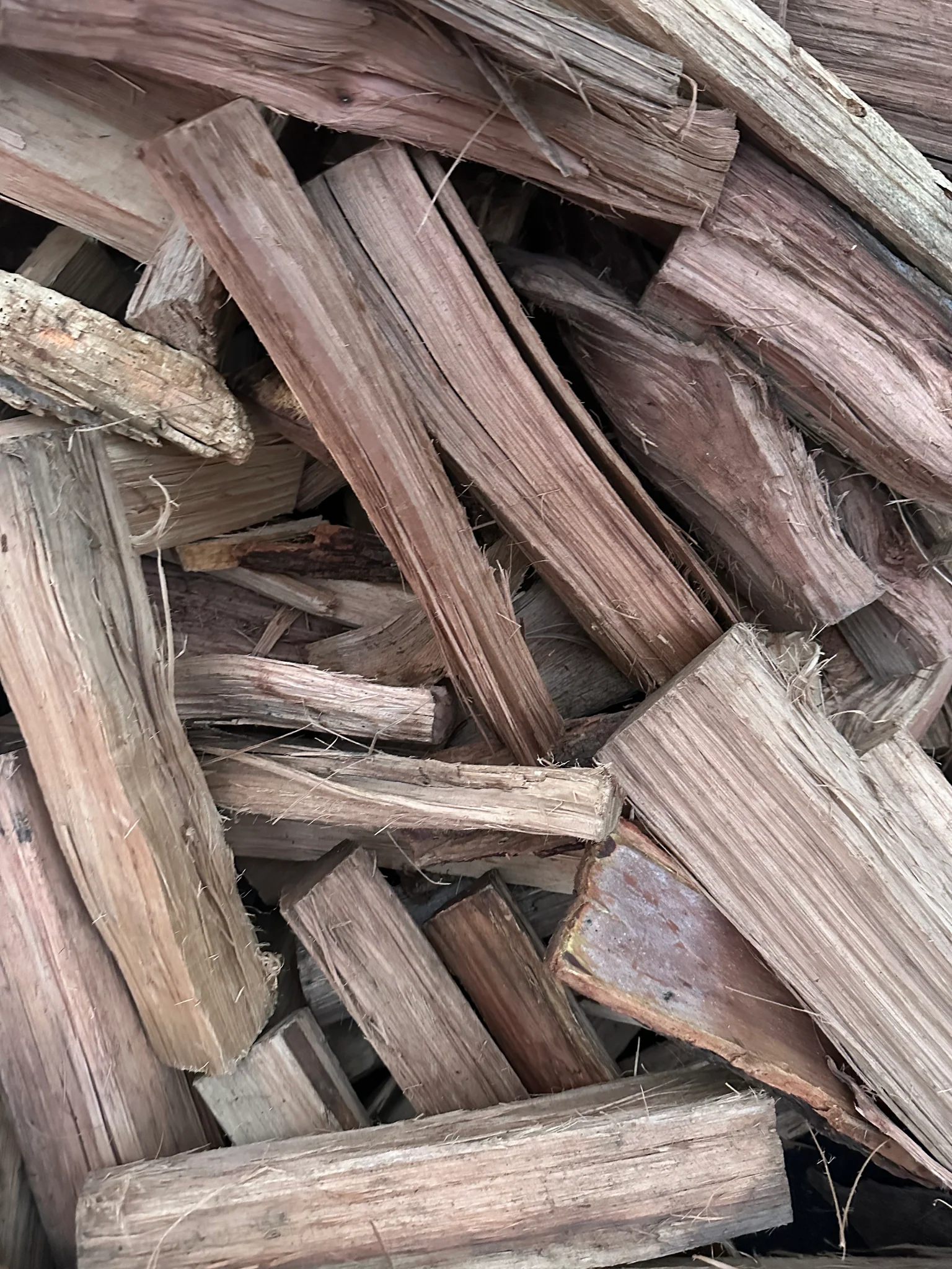Stacked kiln-dried Hickory firewood logs ready to burn for fireplaces, fire pits, and BBQ