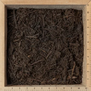 Shredded hardwood mulch applied around flower beds and garden landscaping